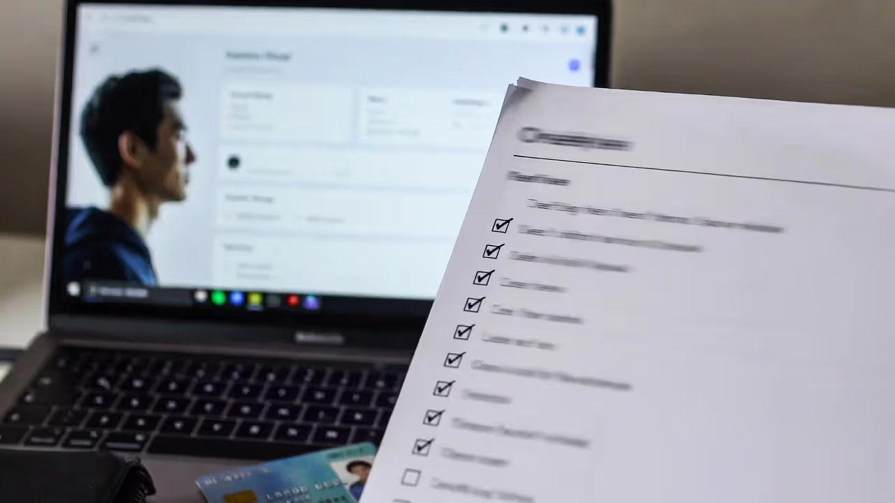 Laptop with a blurred coach profile next to a checklist page used to vet an esports coach.