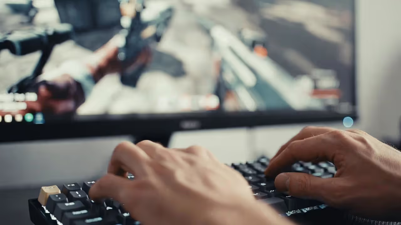 Gamer using WASD keys on a mechanical keyboard during a shooter match